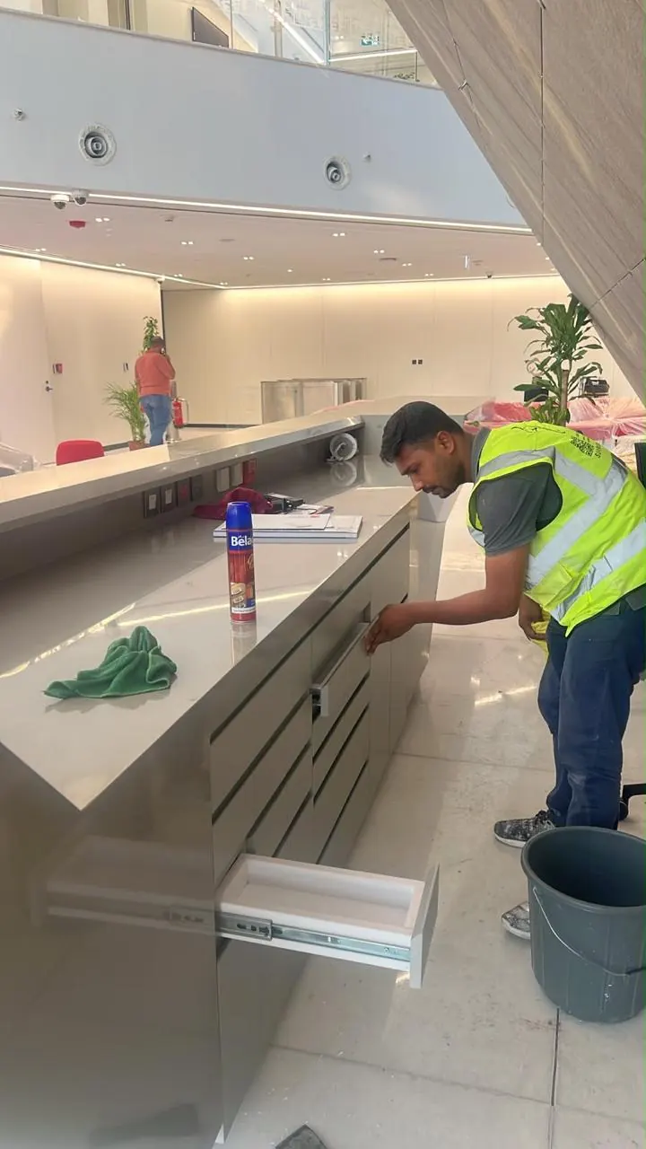 عامل يمسح داخل أدراج كاونتر مفتوحة