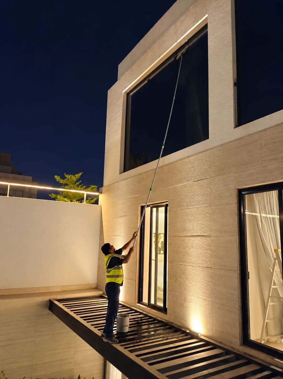 Cleaning villa windows with a long pole